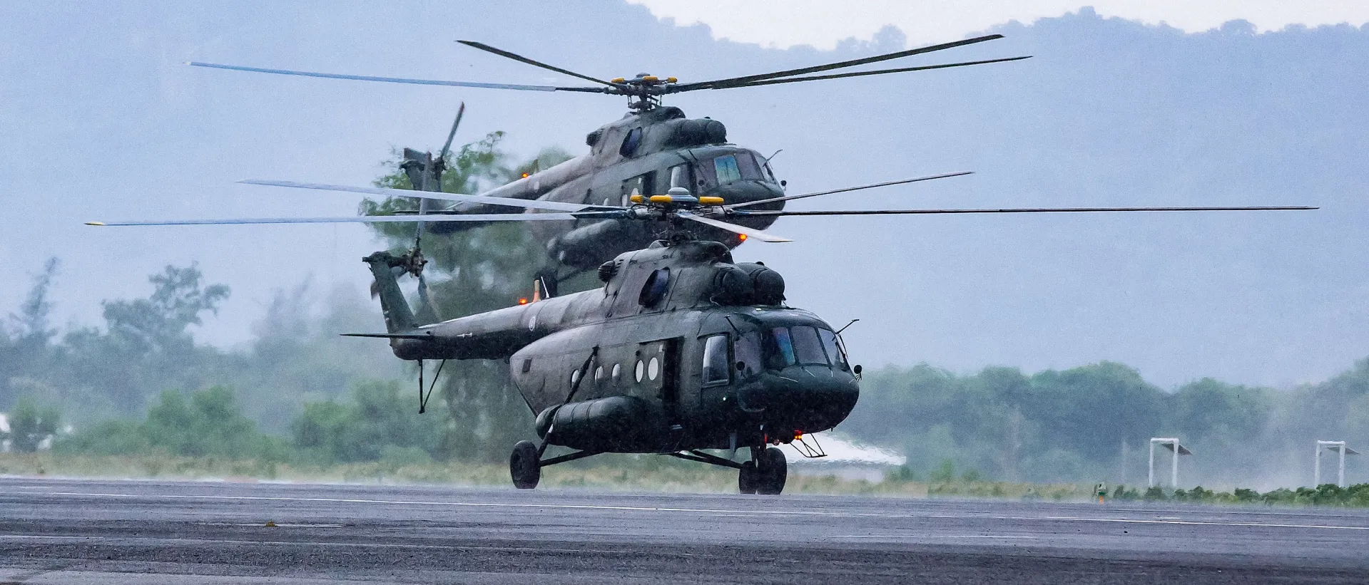 Military commando helicopters landing on asphalt ground