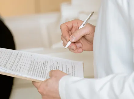 Photo Of Person Holding Paper And Pen