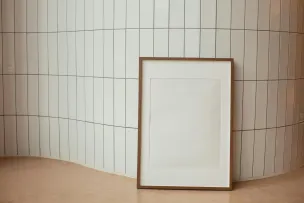 Rectangular empty photo frame against tiled wall