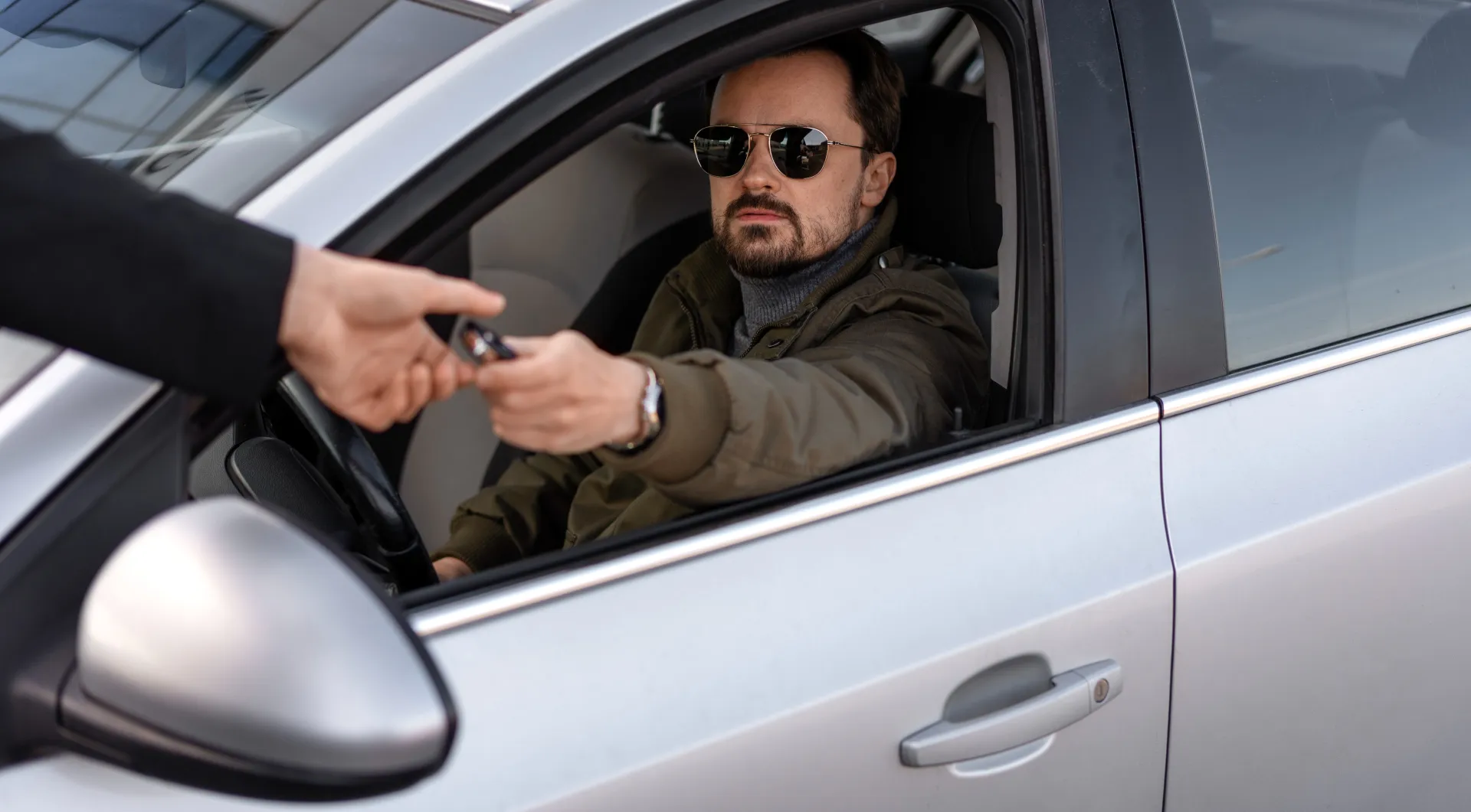 A Man Sitting Inside the Car Looking at the Police Officer Writing on the Traffic Ticket