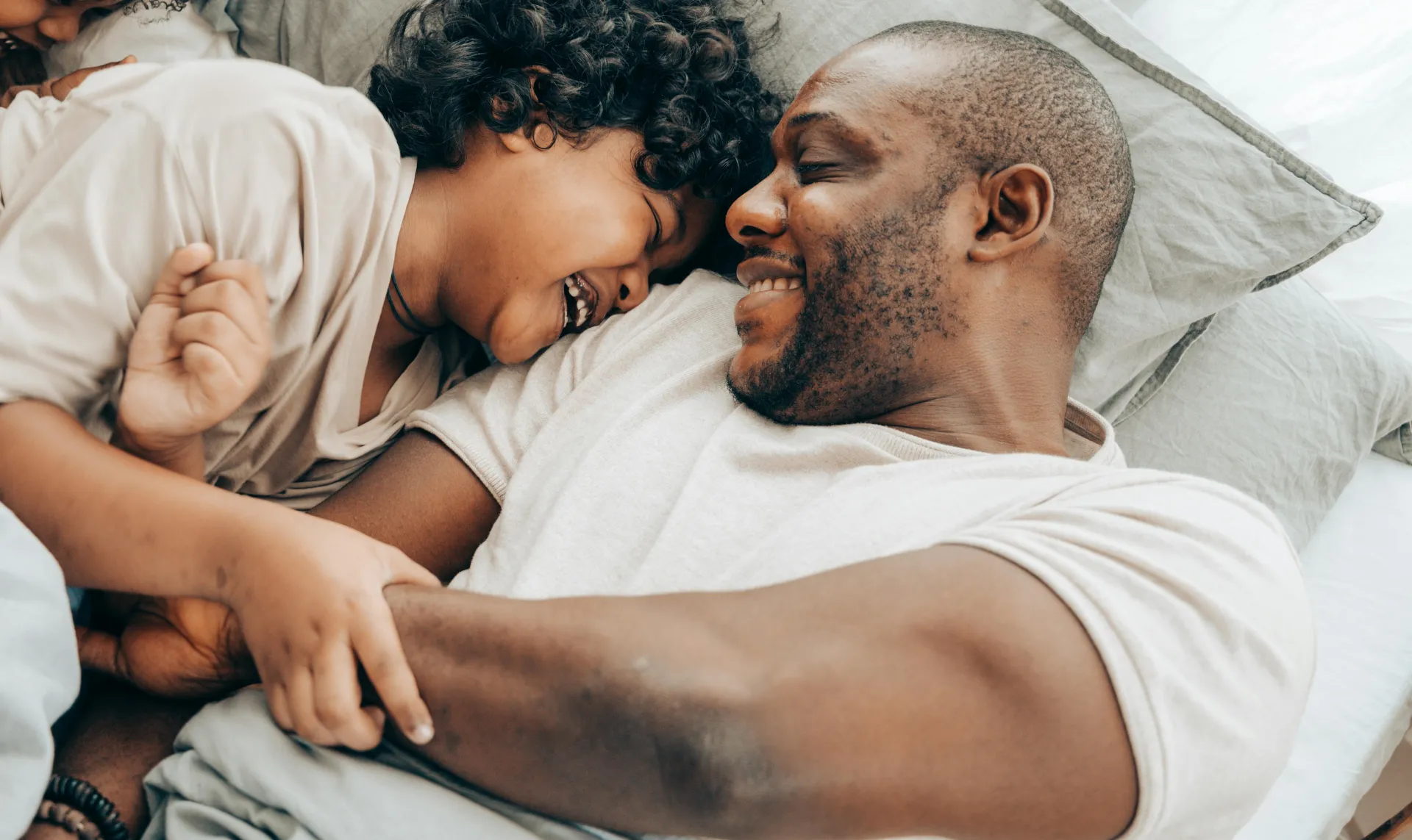 Laughing black father playing with children