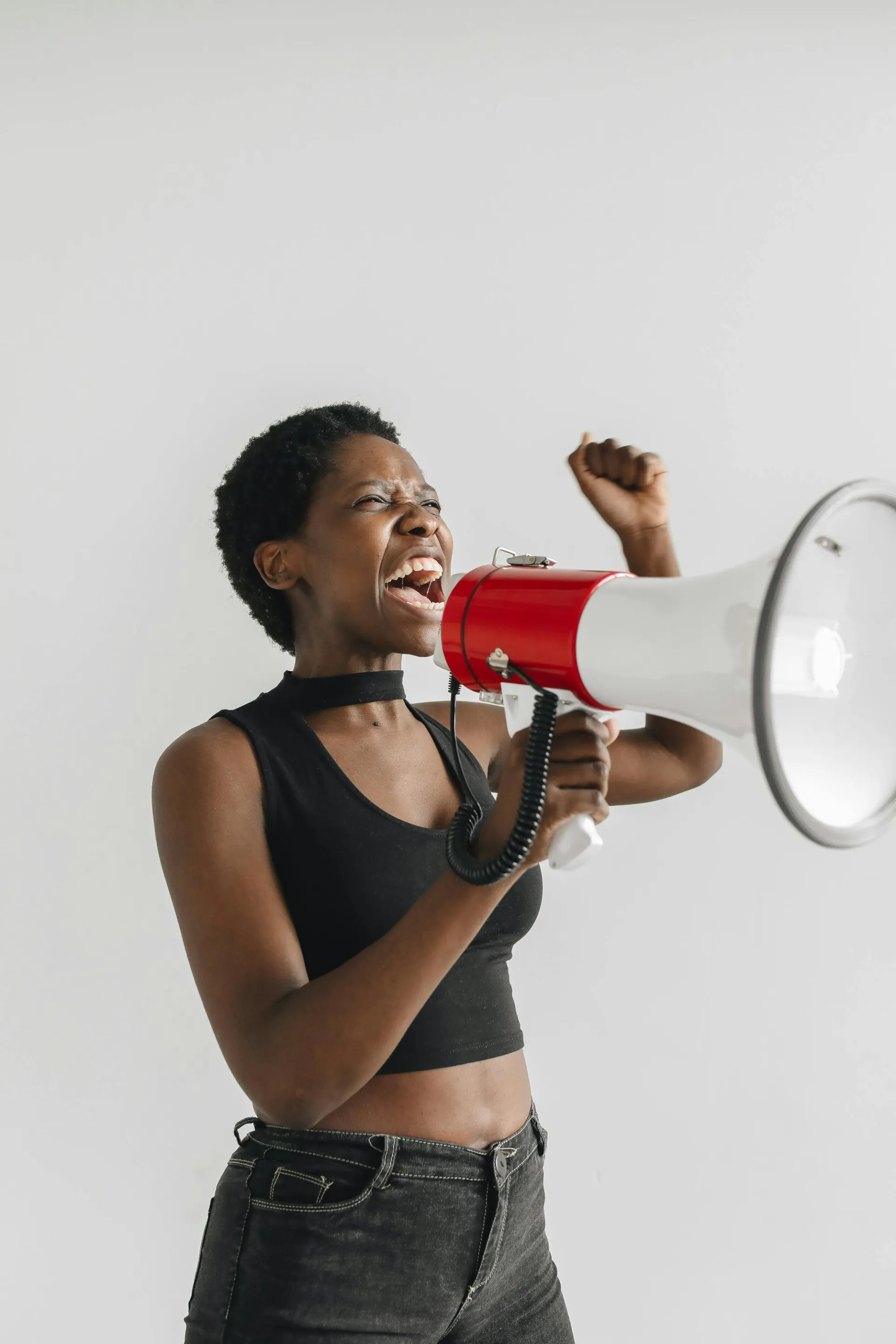 An inspired woman energetically uses a megaphone during a protest, symbolizing activism and empowerment.