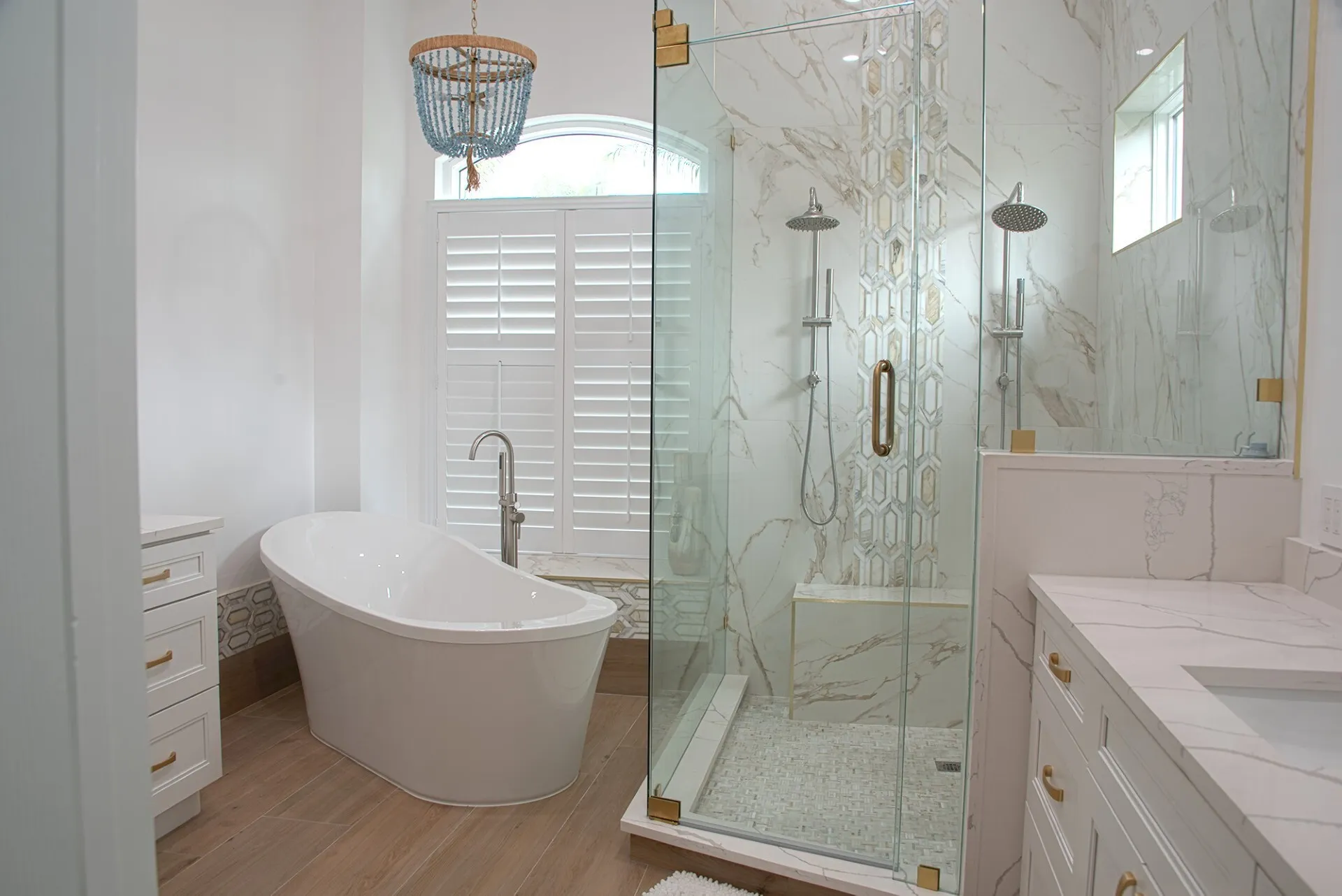 open bathroom with large white bathtub, fully glass open shower and white granite countertops
