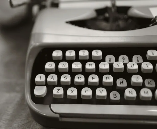 Detailed close-up of a vintage typewriter keyboard in black and white.