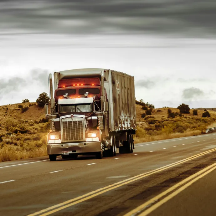 A large truck driving on a desert highway in Nevada, USA. Perfect for transportation themes.