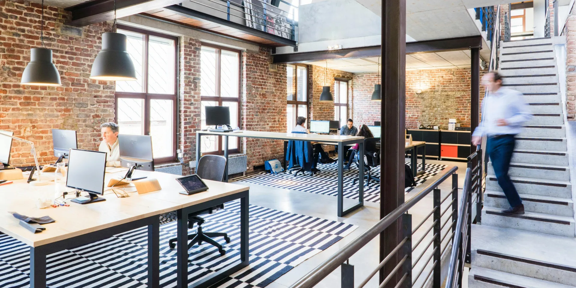 Spacious and stylish open-plan office with loft and industrial aesthetic.