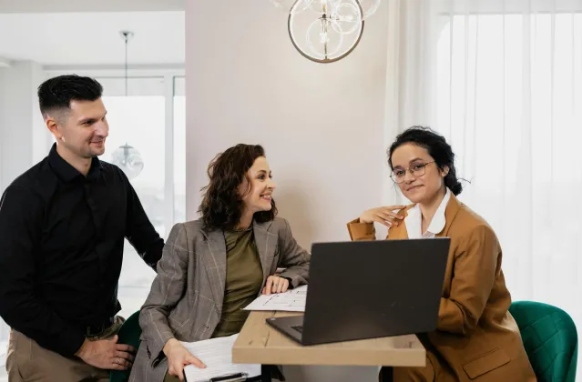 Professional business meeting with real estate consultant and couple in an office setting.