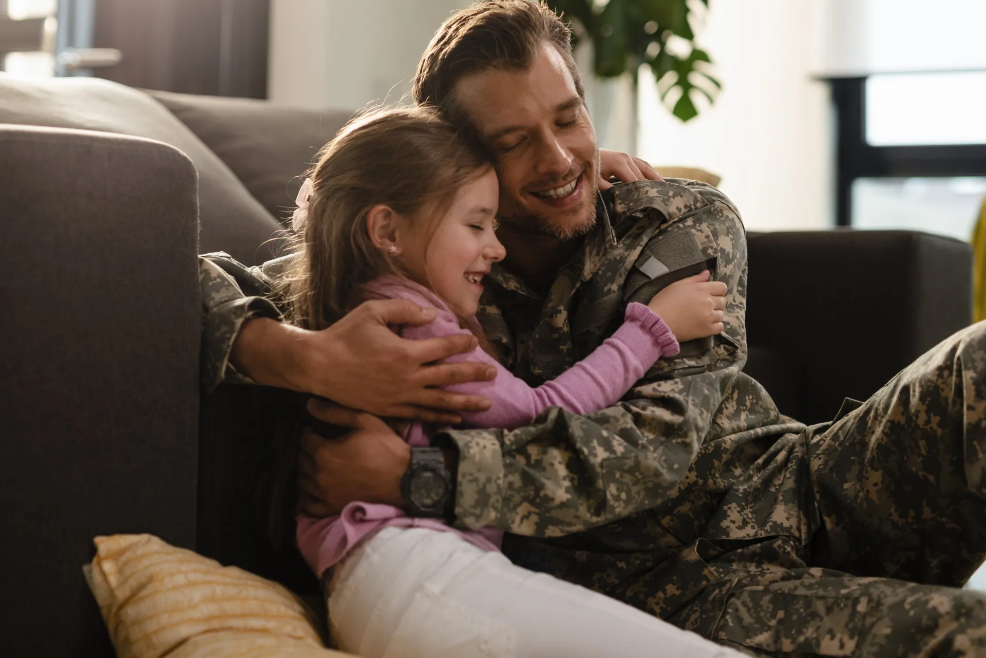 A soldier and partner share a loving embrace indoors, symbolizing reunion and love.