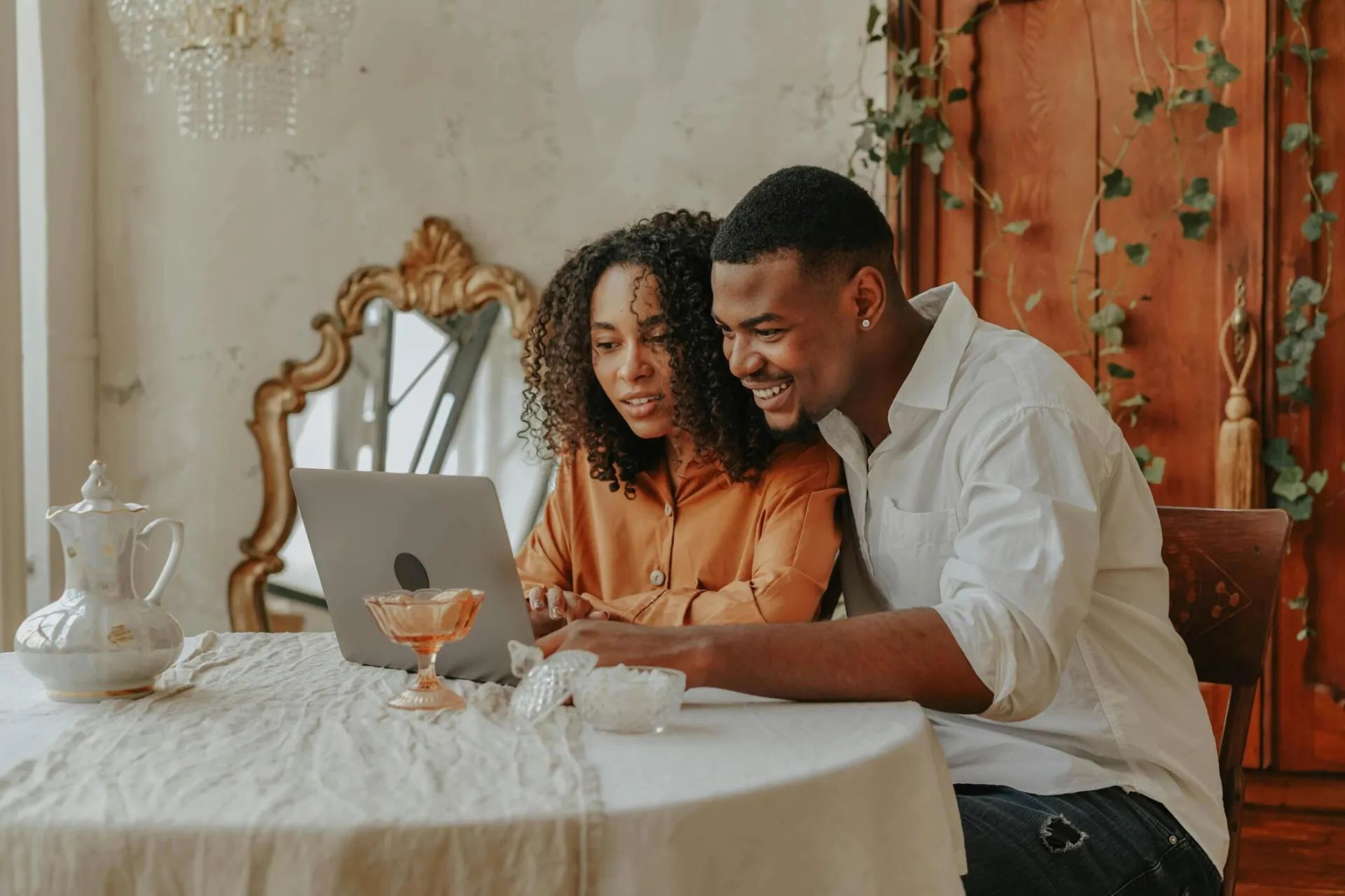 Smiling couple using a laptop together at home, enjoying their time indoors.