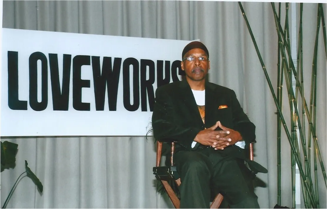 Naim Muslim setting in a chair promoting the idea "love it forward."