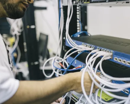 Electronics Engineer Fixing Cables on Server