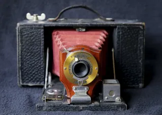 Black and Red Camera on Blue Textile