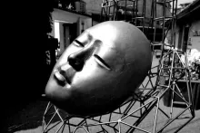 Striking black and white outdoor sculpture of a face in an art installation.