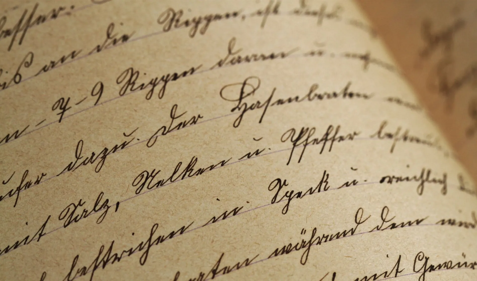 Close-up of vintage handwriting on antique aged paper with sepia tones.