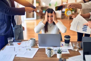 Cheerful man with coffee mug sitting in modern office with plant.