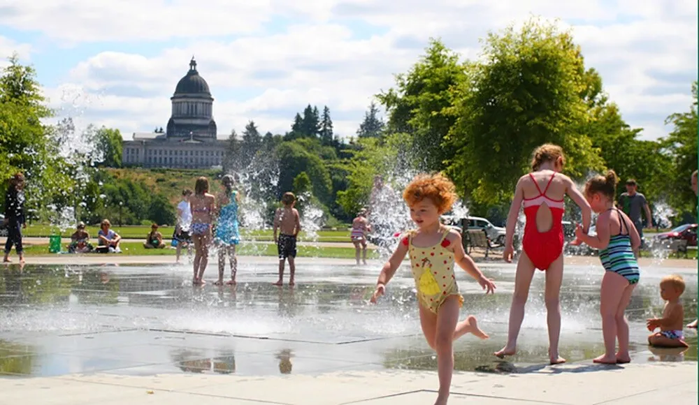 The Idaho State Capitol Building stands majestically under a clear blue sky with surrounding gardens.