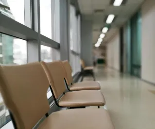 Row of empty chairs in a hospital corridor, soft lighting and modern interior design.
