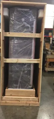 A worker in a red shirt loads boxed appliances onto a truck for delivery.
