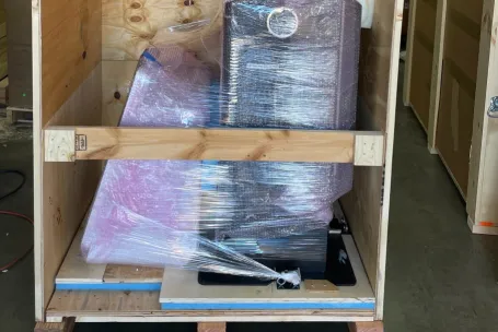 Delivery person in red uniform checks packages. Outdoor location, Portugal.