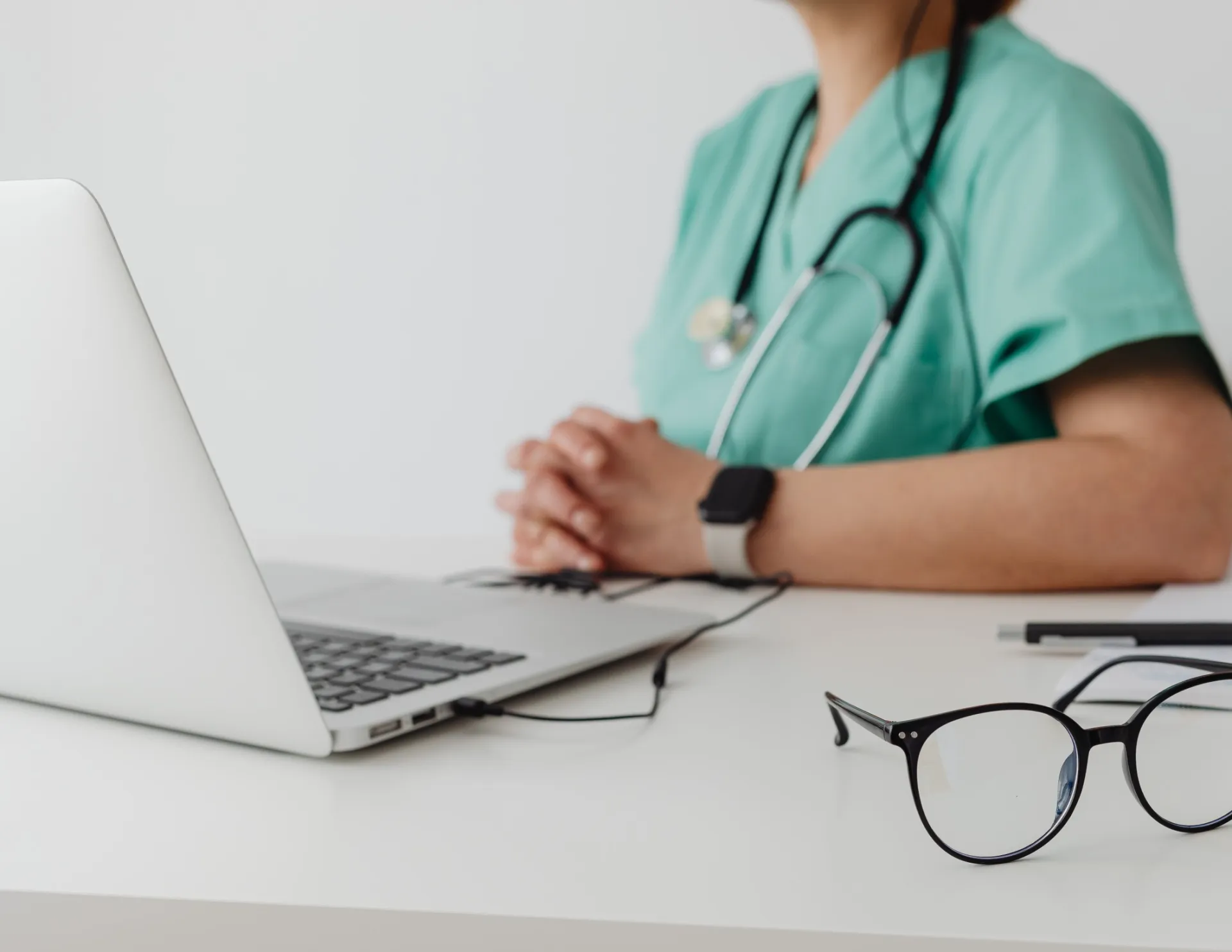 Woman in Blue Scrub Suit Using Macbook Pro