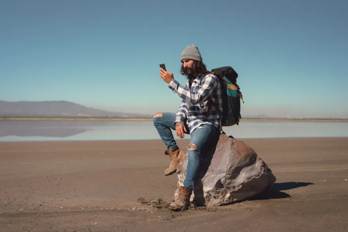 Man in Blue Denim Jeans Sitting on a Rock