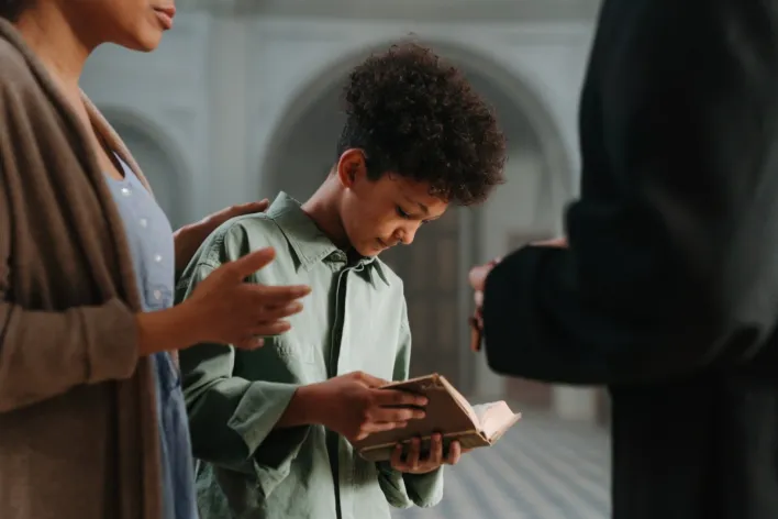 A  Boy Holding a Bible