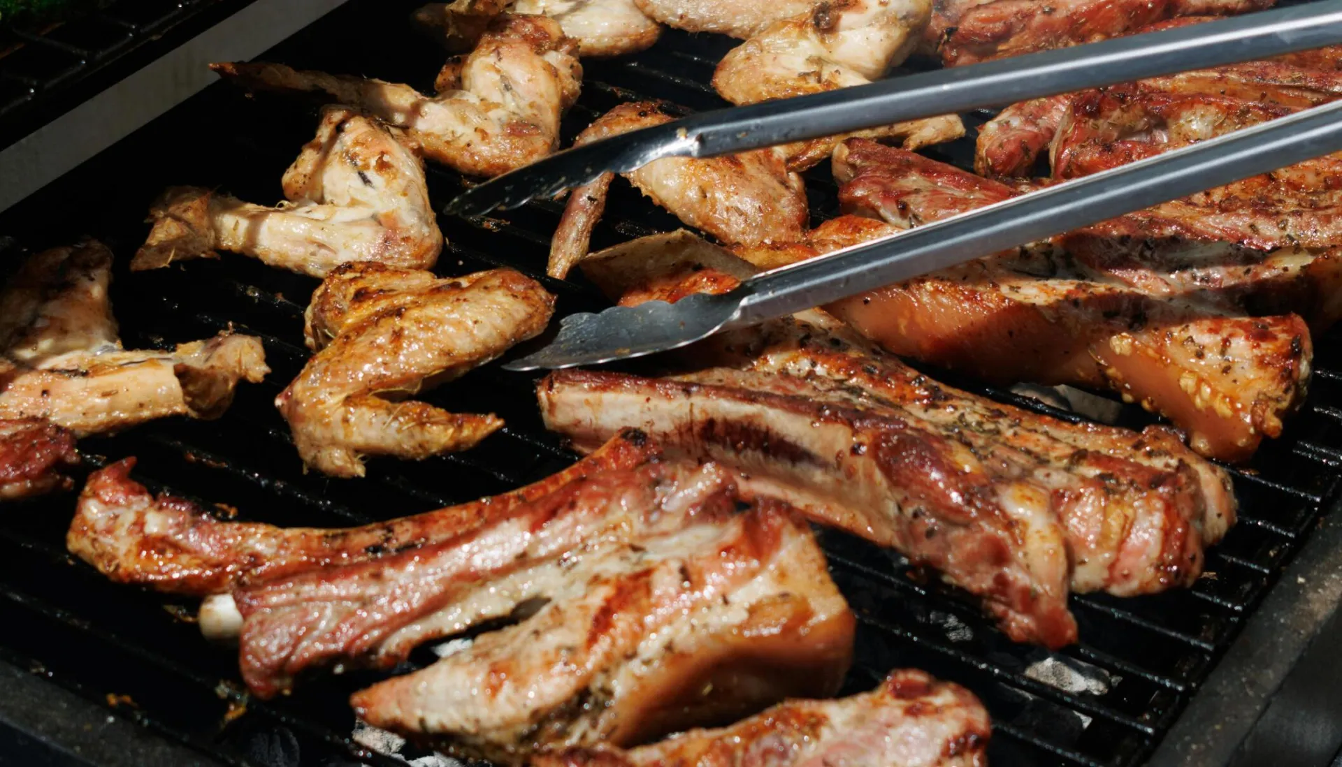 Delicious barbecue chicken and zucchini grilling outdoors on a sunny day.