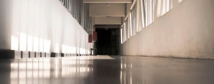 A spacious corridor with a modern design highlighted by natural light streaming in.