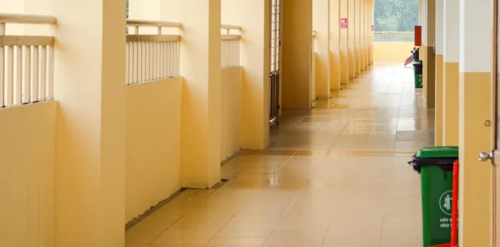 A spacious yellow corridor with trash bins, ideal for background or architectural themes.