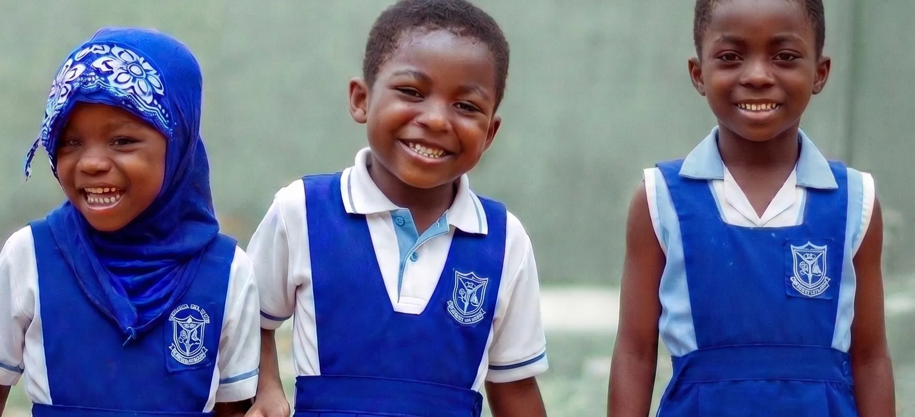 Happy children in school uniforms smiling and enjoying break time outside in Accra, Ghana.