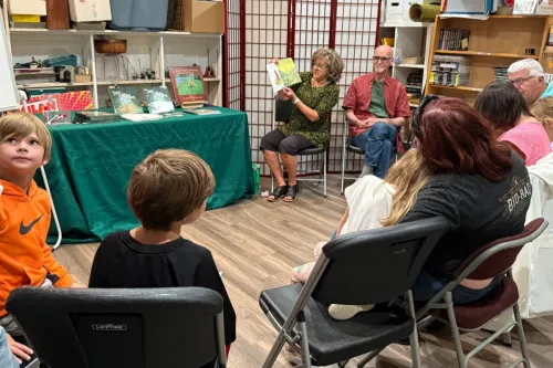 People sitting around on chairs, Gail Kuhnlein, author, reading Into the Thicket