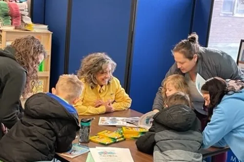 Gail in a classroom working on an art project with children and parents.