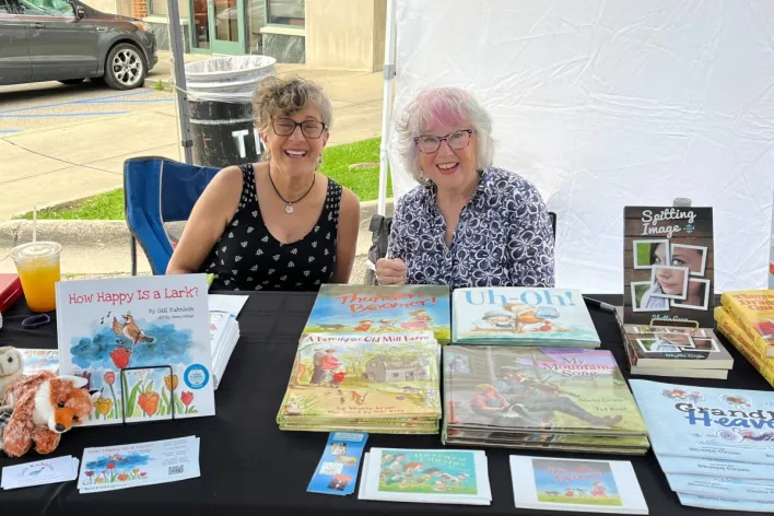 Two women at a table with their picture books