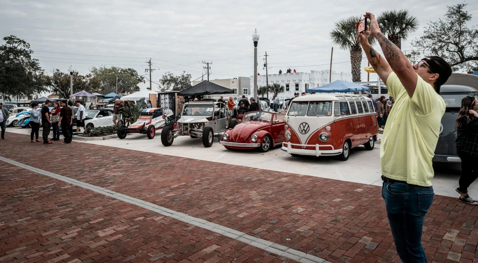 A man taking a photo of a row of cars