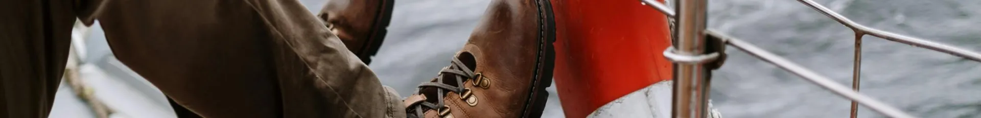 Shoes on the Legs of a Man Sitting on a Sailboat