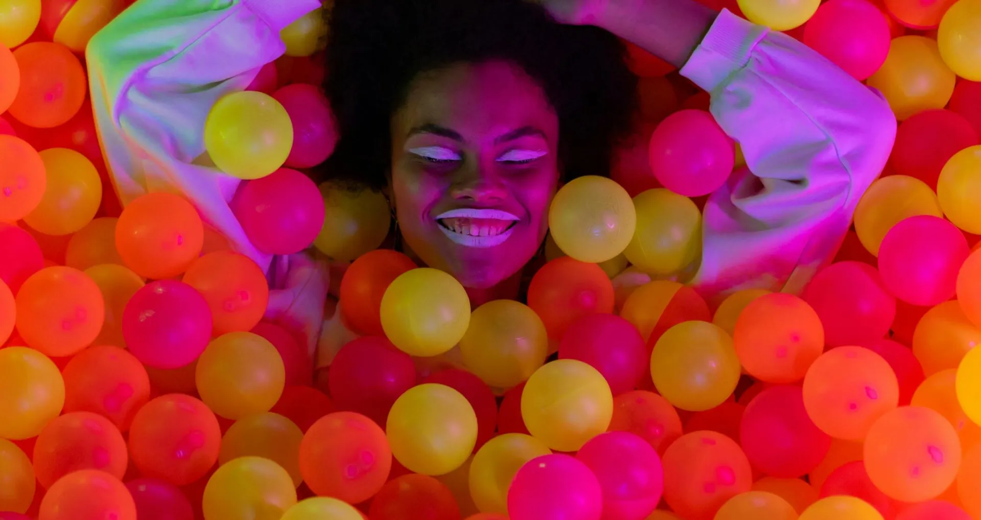 A Happy Woman Lying on Ball Pit