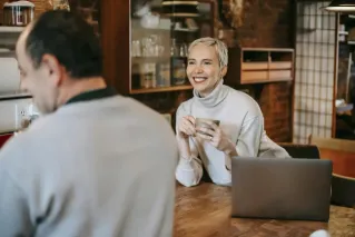 Content woman with coffee talking to boyfriend at home