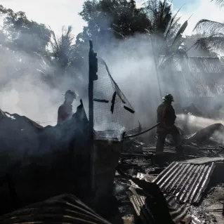 Silhouette of Fireman Holding Hose
