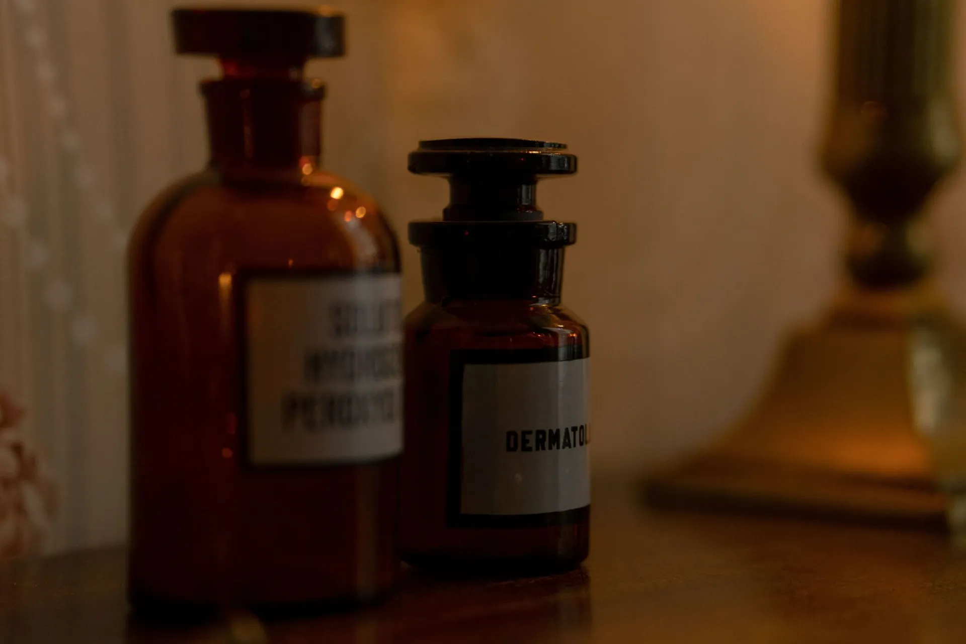 Close-up of vintage amber glass bottles with labels on a wooden surface, exuding a classic vibe.