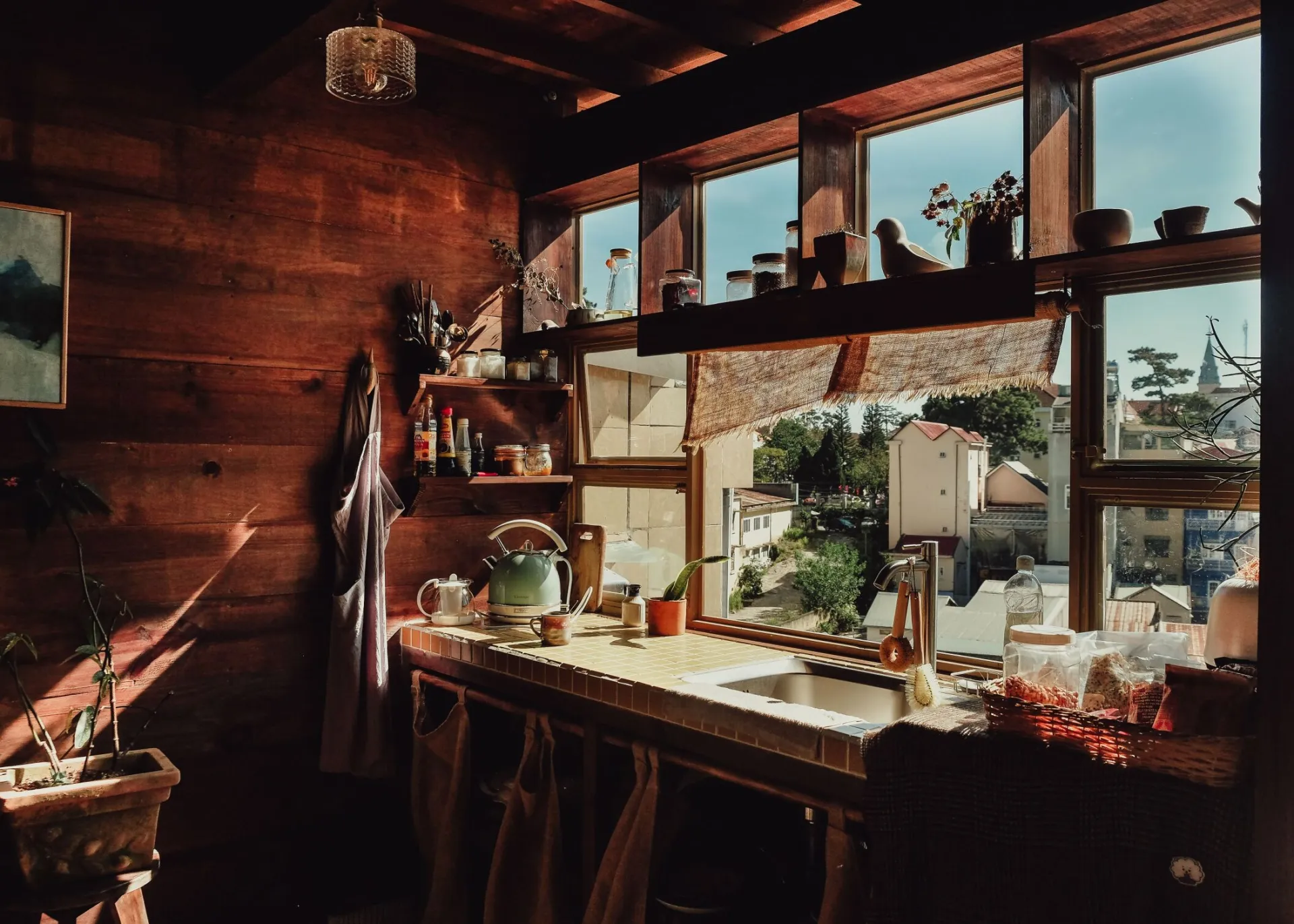 Sunlit rustic kitchen interior with wooden accents and a scenic outdoor view through the window.