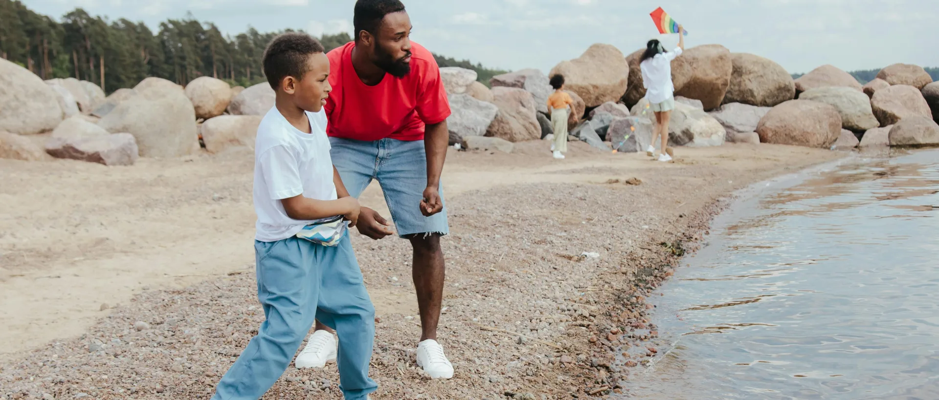 A Man and a Young Boy Throwing Rocks on Water