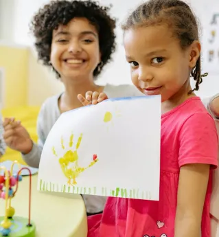 Girl in Pink Dress Holding White Paper With Painting Of Her Hand