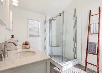 Bright white bathroom with towel ladder and cream countertops