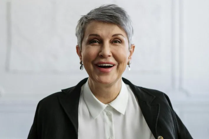 Confident woman smiling in an office, ideal for professional themes.