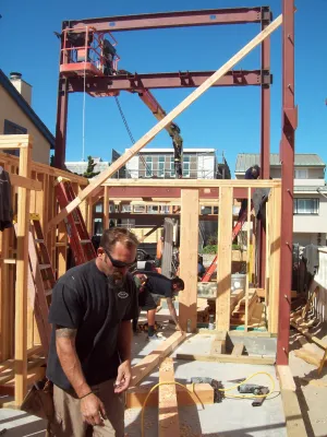 Carpenters framing first floor adjacent to steel moment frame