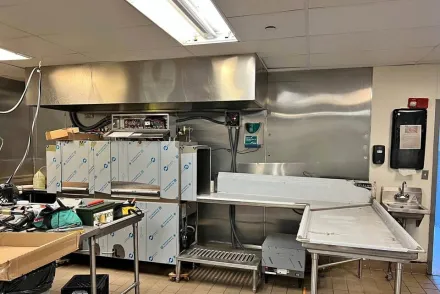 A chef skillfully cooks in a modern kitchen with stainless steel appliances.