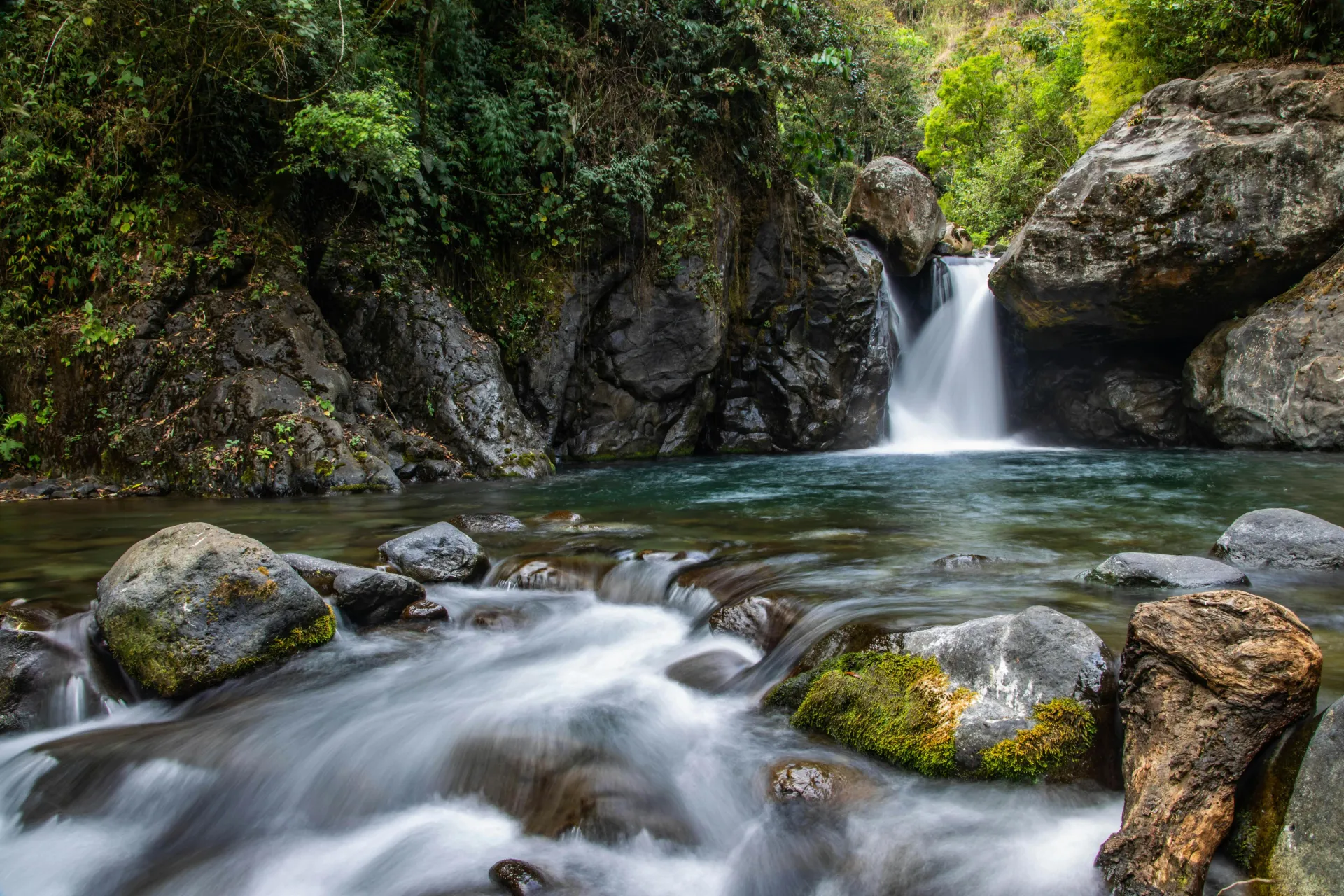 Tranquil waterfall cascading through mossy rocks in a lush forest setting. Perfect for nature lovers.