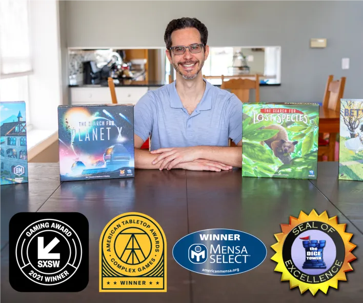 Ben Rosset sitting behind several of his award winning games
