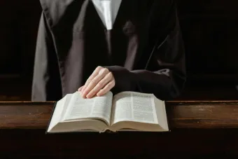 A person in religious attire reading an open Bible, highlighting the connection to spirituality.