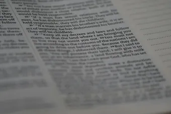 Close-up view of Holy Bible text with soft focus creating a spiritual ambiance.